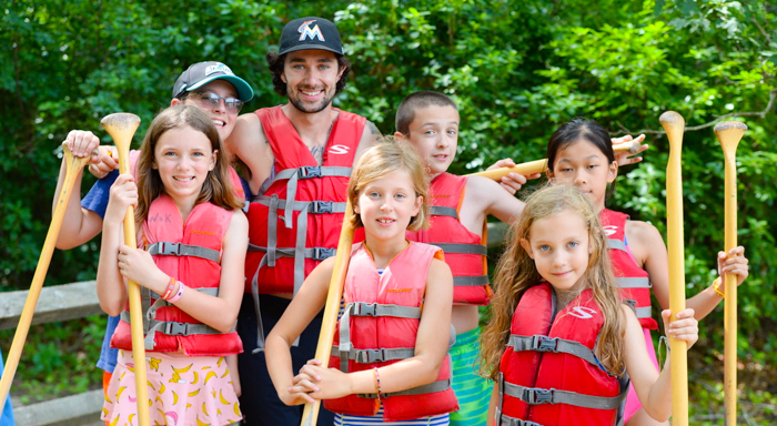 group of kids with canoe paddles