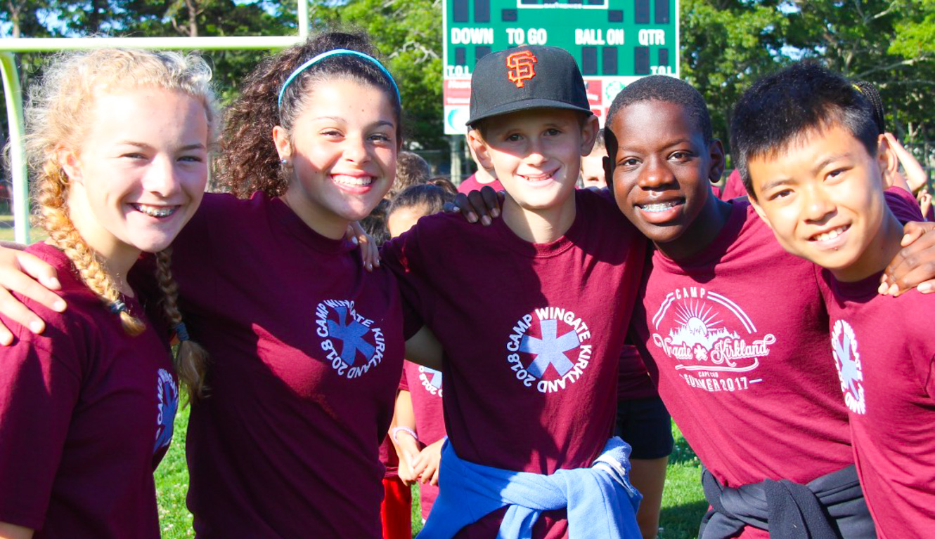 Track meet group smiling together with arms around another